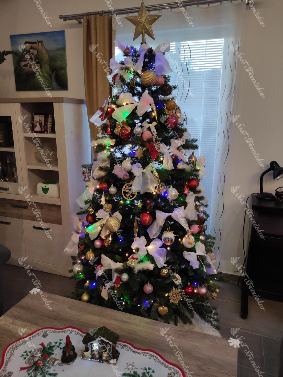 Umelý vianočný stromček FULL 3D Smrek Fínsky 210cm s farebnými vianočnými ozdobami a veľkými bielymi mašľami