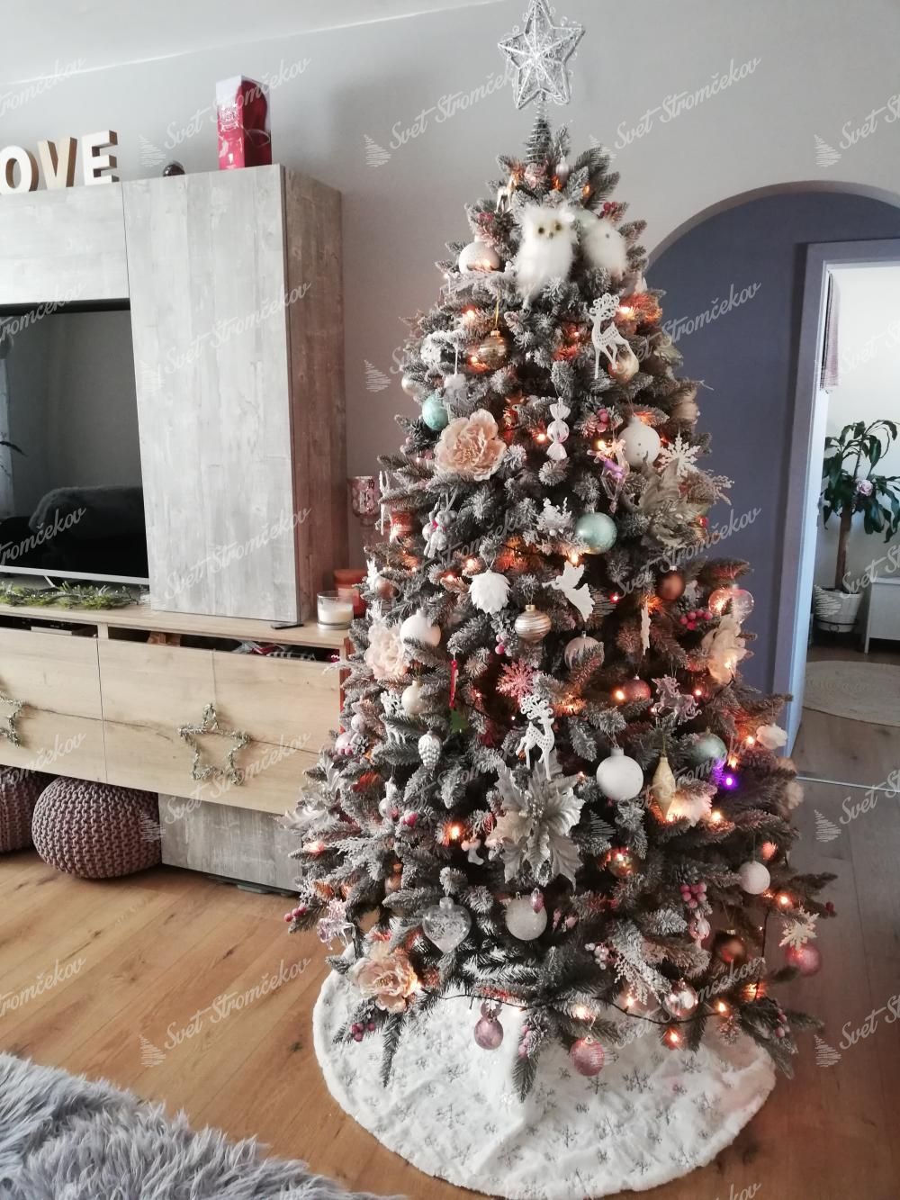 Umelý vianočný stromček Smrek Kryštálový 220cm s bielymi a ružovými vianočnými ozdobami v obývačke