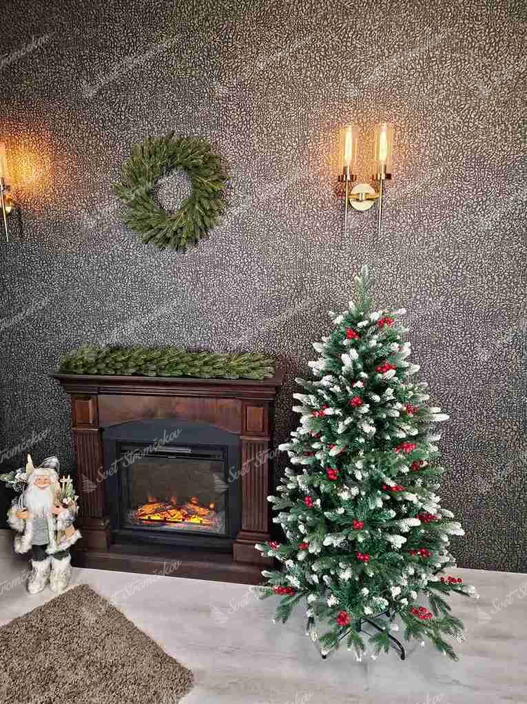 Umelý vianočný stromček 3D Smrek Zasnežený 120cm má zasnežené konce vetičiek a je ozdobený červenými plodmi.