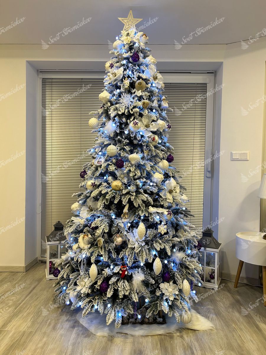 Umelý vianočný stromček 3D Jedľa Alabastrová 210cm ozdobený bielymi a fialovými ozdobami.